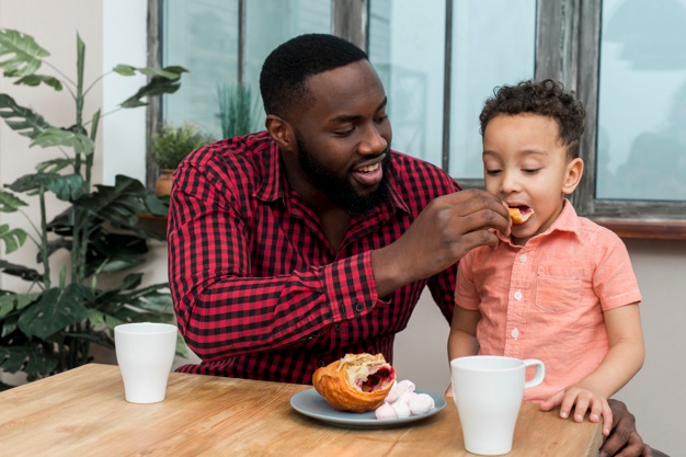 hands on dad feeding his son